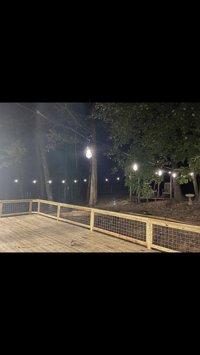 Deck at night with string lights built by Redbone Woodworks