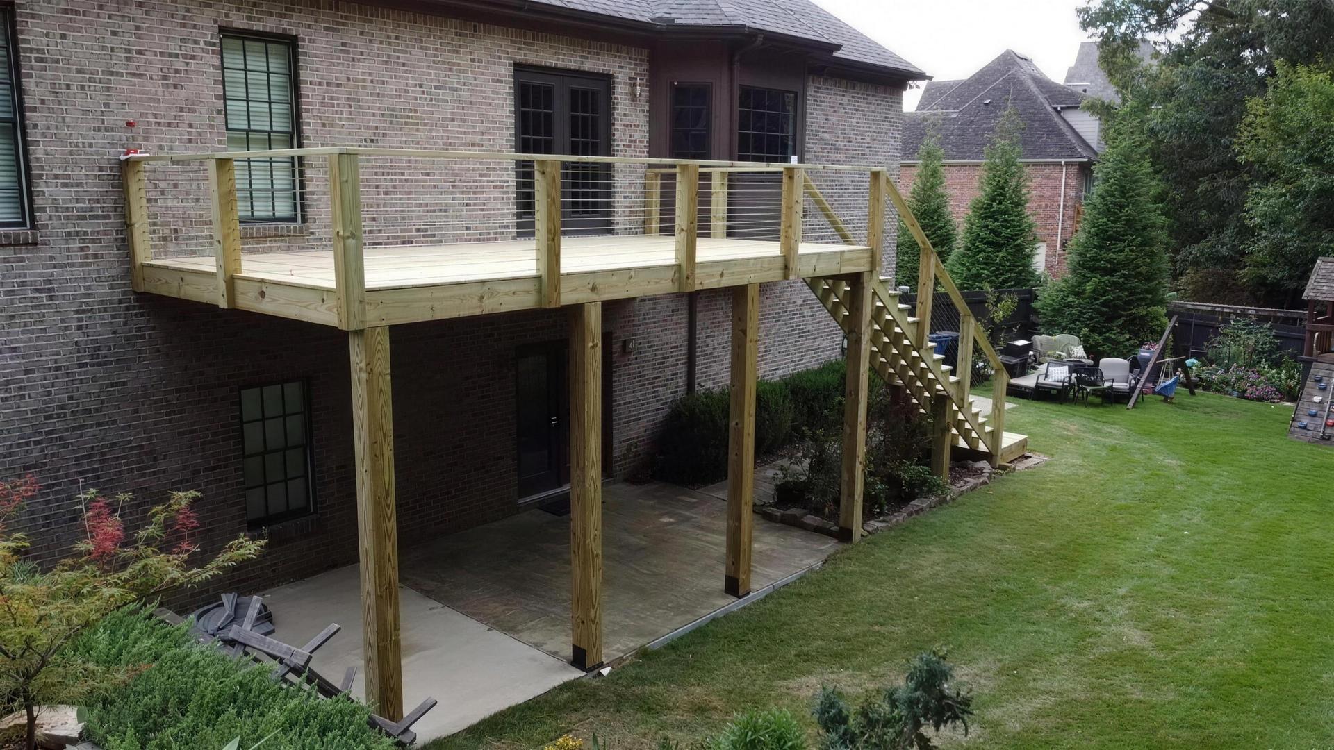 Elevated deck with cable railing and staircase built by Redbone Woodworks, a deck builder in Birmingham, AL